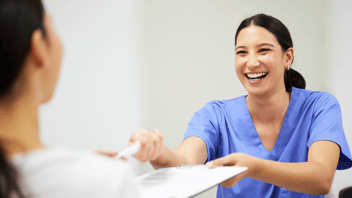 Woman handing a patient in-take forms