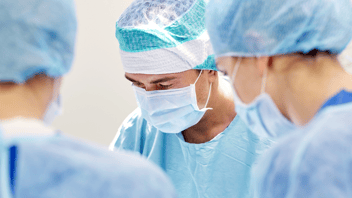 Three doctors in scrubs ready for an operation 