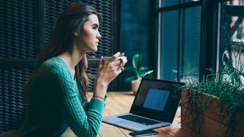 Woman holding a mug looking out of the window