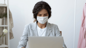 Woman wearing a mask in a call on her laptop