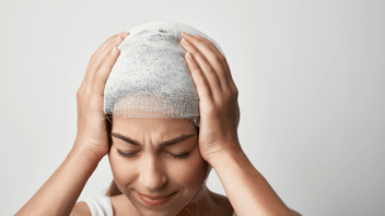 Woman with her hands to her hand bandaged in distress 