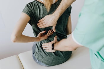 A physiatrist performs physical therapy exercises with a patient at a pain management clinic.